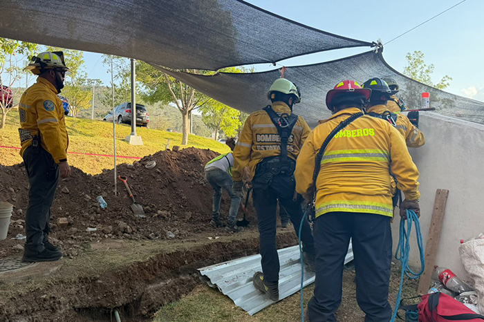 Elementos de Protección Civil Estatal y rescatistas realizando maniobras de excavación manual para liberar a una persona atrapada.