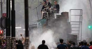 Integrantes de U2 (Bono, The Edge, Adam Clayton y Larry Mullen Jr.) sobre un autobús intervenido por Chavis Mármol en el Centro Histórico.