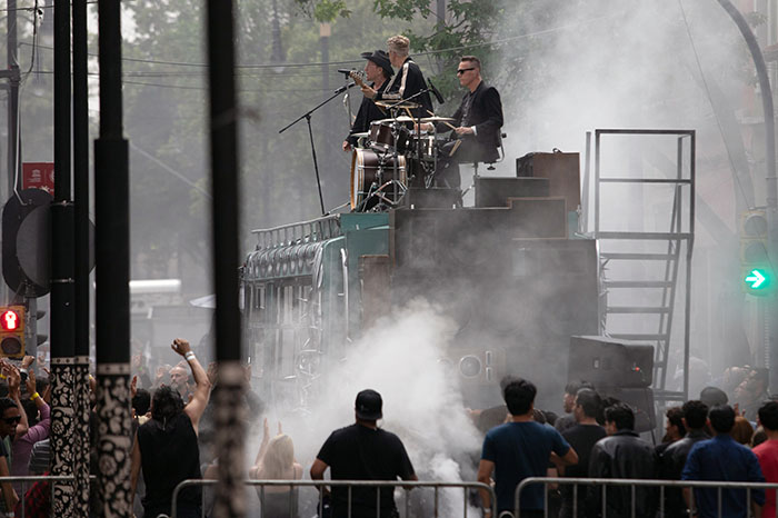 Integrantes de U2 (Bono, The Edge, Adam Clayton y Larry Mullen Jr.) sobre un autobús intervenido por Chavis Mármol en el Centro Histórico.