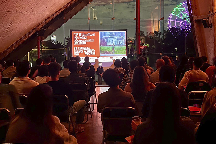 Sala de cine alternativa proyectando un largometraje documental independiente durante un festival de diversidad.