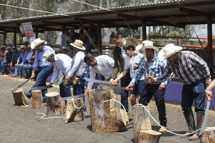 Alfonso Martínez Alcázar cortando el listón inaugural de la expo ganadera en el municipio de Morelia junto a productores locales.