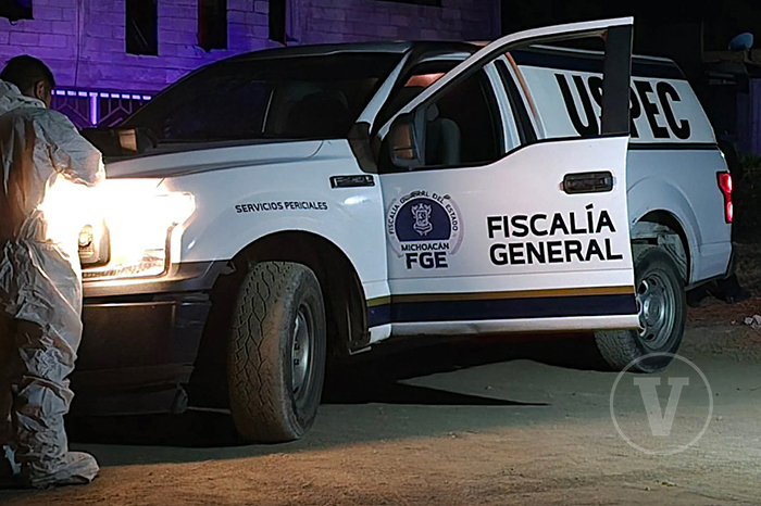 Elementos de la policía y la Fiscalía resguardan la calle Hermanos Serdán en Apatzingán tras un ataque armado.