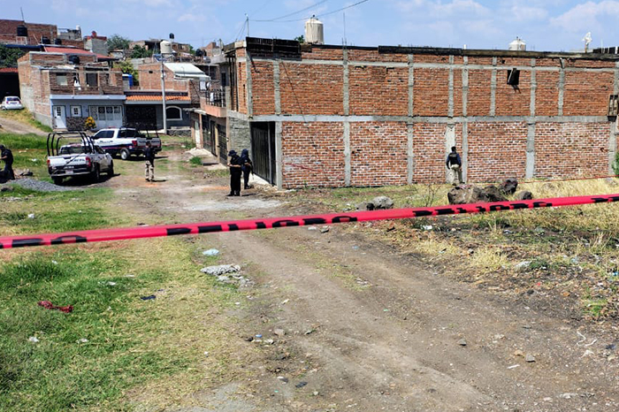 Patrulla de la Policía Municipal resguardando un perímetro acordonado con cinta amarilla en una calle del municipio de Jacona.