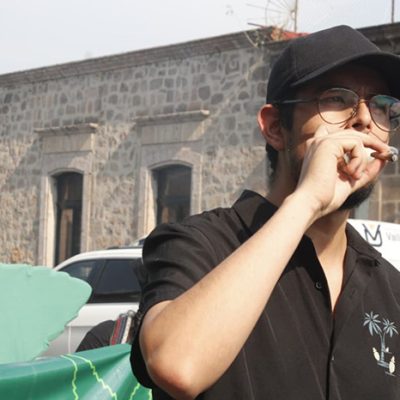 Manifestantes marchando por la avenida Madero de Morelia con pancartas a favor de la legalización del cannabis.