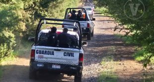 Elementos de la Guardia Civil resguardando camionetas aseguradas en un camino de terracería rural.