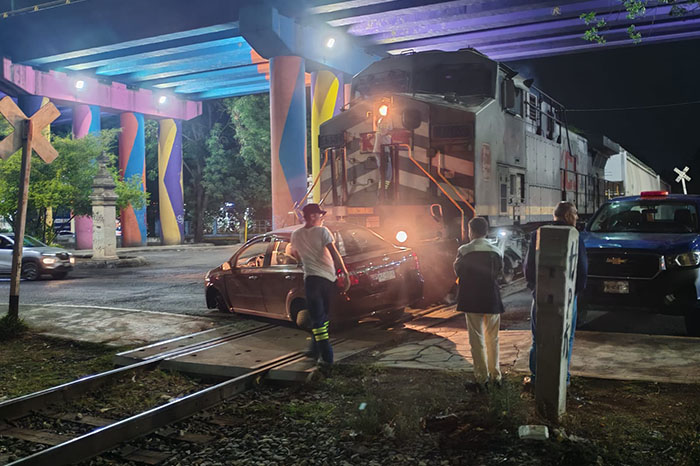 Tren de Kansas City Southern tras impactar a un auto Chevrolet Aveo rojo en Tres Puentes, Morelia.