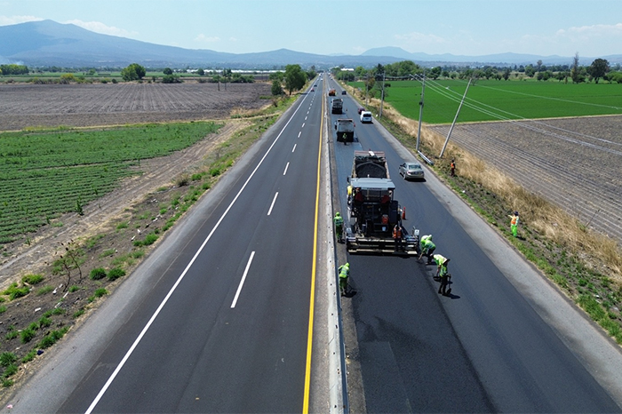Maquinaria pesada del programa Trenes de Pavimentación realizando trabajos de reasfaltado en una carretera federal.