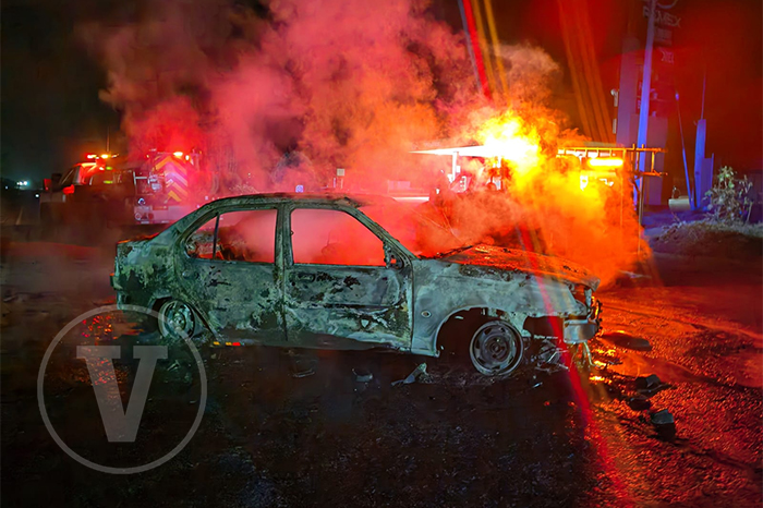 Fotografía de un automóvil completamente calcinado y abandonado sobre el asfalto de la carretera Zinapécuaro-Álvaro Obregón tras el enfrentamiento armado.