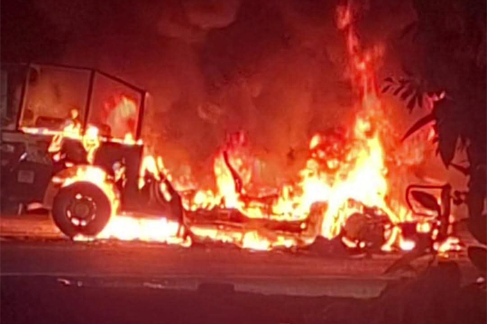 Restos de un autobús de pasajeros incendiado sobre la carpeta asfáltica de la carretera costera en Michoacán.
