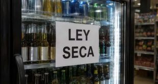 Refrigeradores y estantes de bebidas alcohólicas con sellos de restricción o avisos de prohibición en un comercio.
