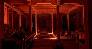 Instalación artística inmersiva interactiva en un antiguo complejo textil industrial de Michoacán con espectadores sentados al fondo.