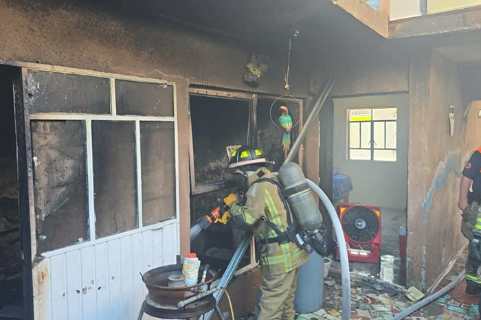 Elementos de Bomberos de la CEPCM desplegando mangueras para asegurar un inmueble tras un incendio en Morelia.