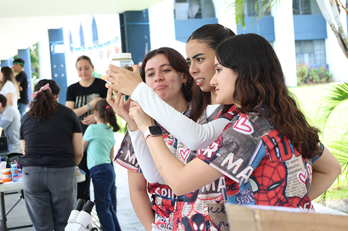 Familias participando en experimentos y talleres científicos durante el Tianguis de la Ciencia en la UMSNH.