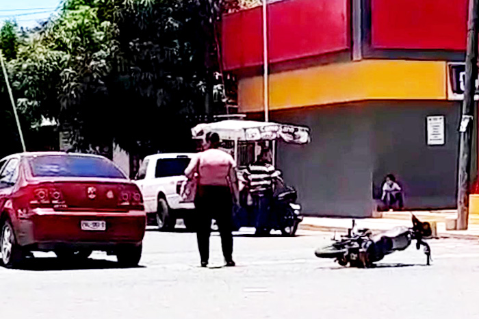 Paramédicos auxilian en la avenida Corregidora luego de que una adolescente motociclista resulta herida por un choque en Apatzingán.