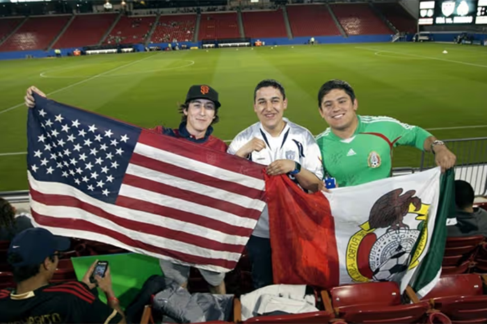 Aficionados con camisetas y banderas celebrando un partido, reflejando cómo crece la afición por el futbol en Norteamérica.