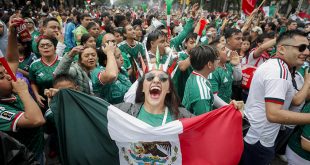 Aficionados celebrando la victoria de la selección mexicana mientras se observan movilizaciones sociales en Ciudad de México.