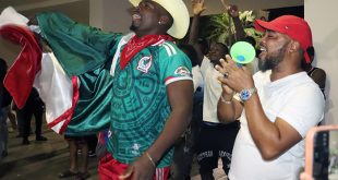 Integrantes de la comunidad de migrantes haitianos en México se congregan en el parque de Tapachula con camisetas y banderas.