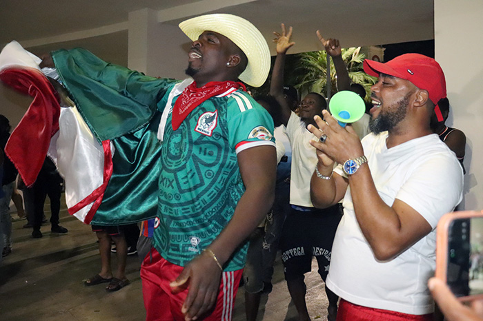 Integrantes de la comunidad de migrantes haitianos en México se congregan en el parque de Tapachula con camisetas y banderas.