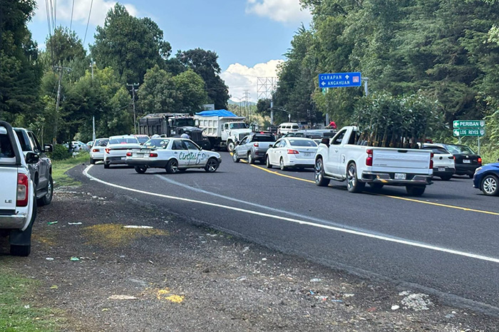 Vehículos de carga atravesados en la vialidad debido a que habitantes bloquean la carretera Uruapan-Paracho por personas desaparecidas.