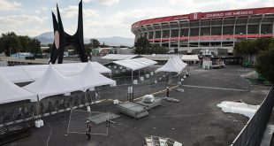 Vecinos caminando cerca del Estadio Ciudad de México ante las vallas de seguridad y filtros implementados para el Mundial.