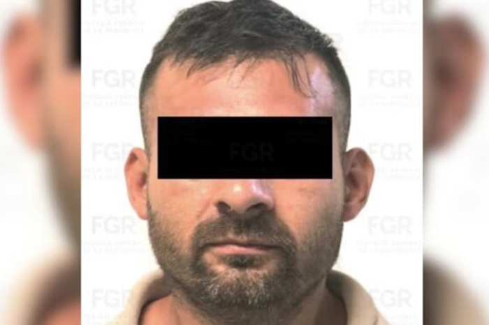 Agentes federales custodian a un reclamado en proceso de extradición a Estados Unidos en el AICM.