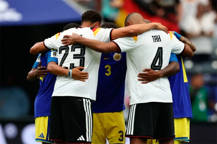 Futbolistas de Alemania y Curazao tomados de las manos en un círculo de oración, ejemplificando los gestos de fe en los partidos del Mundial.