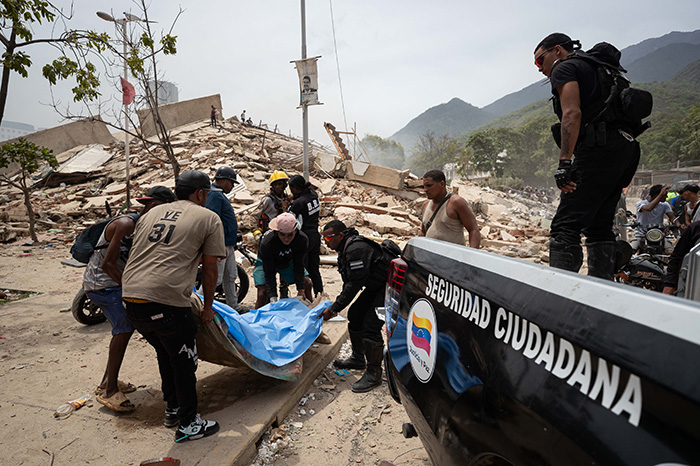 Equipos de rescate y voluntarios trabajando entre los escombros de un edificio colapsado tras los terremotos en Venezuela.