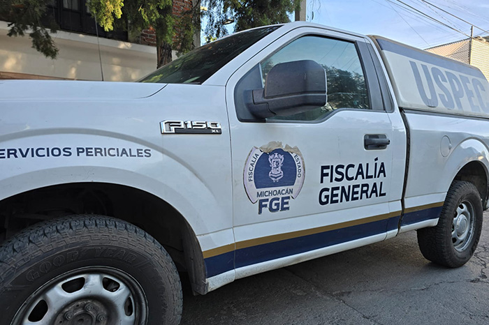 Elementos policiales resguardan la zona donde una mujer fue asesinada a balazos dentro de una vivienda en Indaparapeo.
