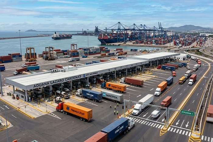 Camiones de carga y contenedores marítimos operando de manera eficiente dentro de la Aduana de Lázaro Cárdenas.