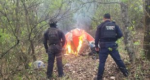 Elementos policiales resguardan cartuchos y equipo táctico decomisados en un narcocampamento en la región de Pátzcuaro.