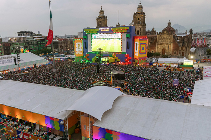Aficionados celebrando un gol frente a las pantallas gigantes instaladas en el Fan Fest de Ciudad de México.