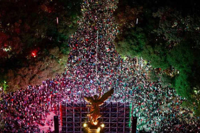 Multitud de aficionados celebrando el triunfo de México en Paseo de la Reforma