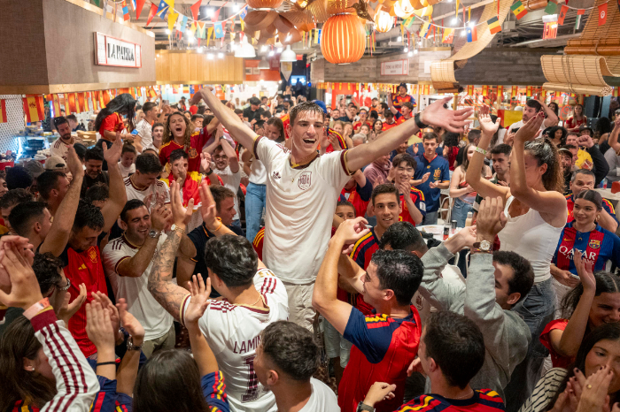 Aficionados españoles celebrando eufóricos el gol de Mikel Merino en el Mercado Little Spain de Nueva York