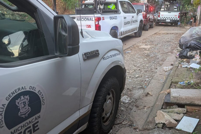 Elementos de seguridad y peritos de la fiscalía en la zona donde fue localizado un cuerpo en Uruapan.