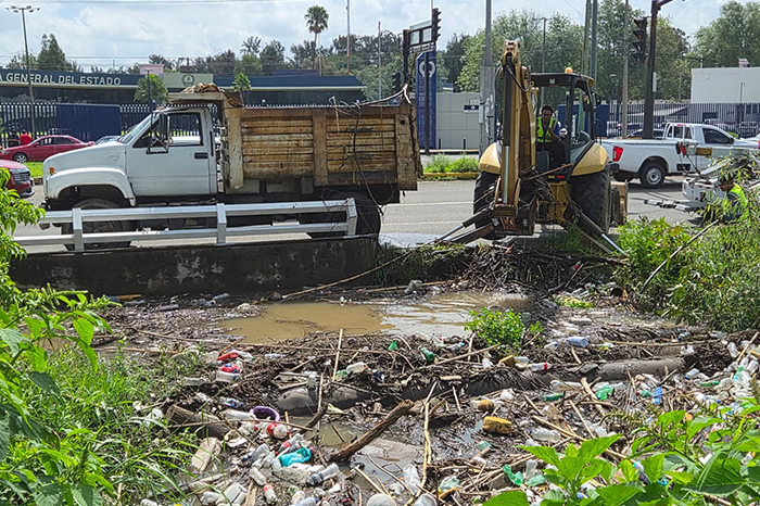 Maquinaria pesada retirando desechos y troncos del Dren Barajas en Morelia.
