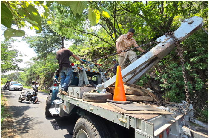 Maniobras con grúas en una carretera sinuosa de Michoacán tras un accidente vial.
