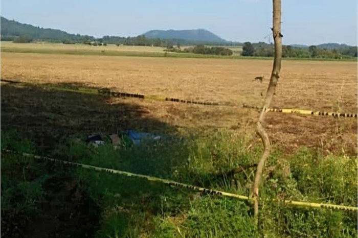 Elementos de la Policía Municipal resguardan la zona donde fue localizado el cadáver de un hombre en un arroyo de Charapan.