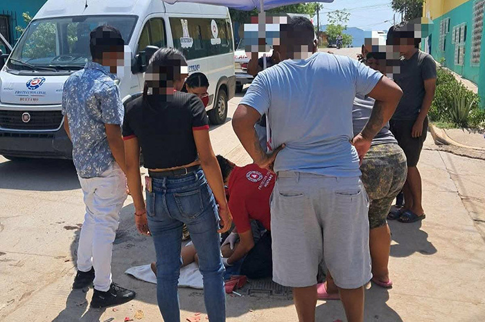 Paramédicos atienden a dos adolescentes heridos tras un choque entre una motocicleta y una camioneta en Huetamo, Michoacán.