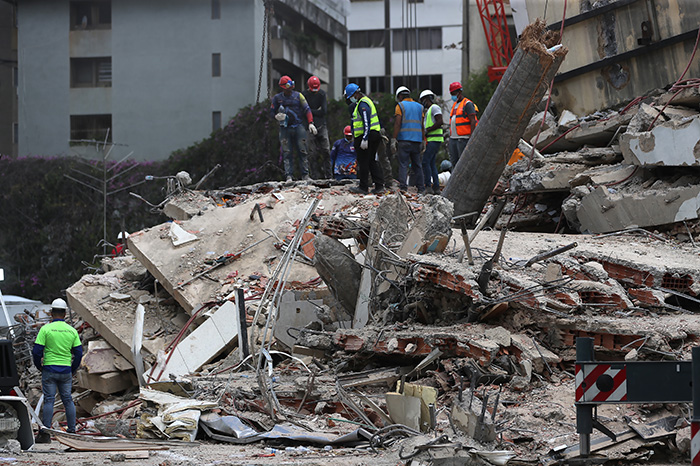 Rescatistas laboran entre los escombros de edificios colapsados tras el sismo en Venezuela.