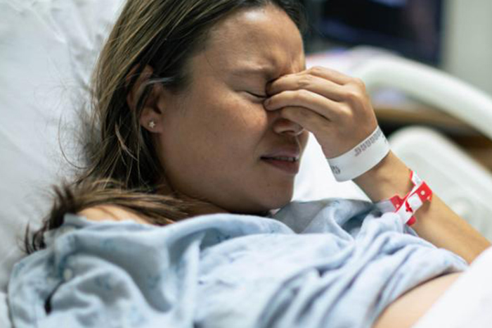 Mujer en la cama de un hospital.