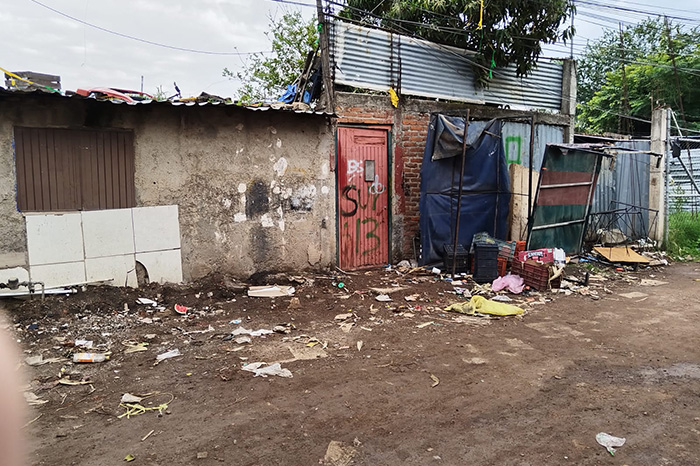 Elementos policiales acordonan un lote baldío tras localizar a un joven asesinado con arma blanca en la colonia Revolución.