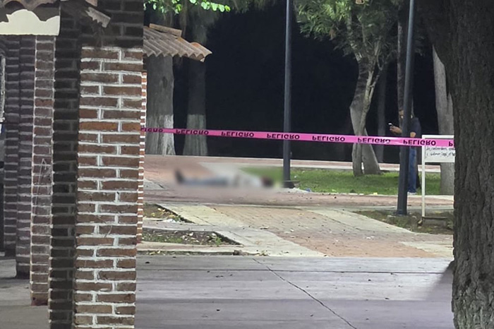 Elementos de seguridad resguardan la zona donde un joven fue asesinado a balazos en la Presa de La Luz, en el municipio de Jacona.