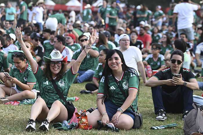 Jóvenes aficionados interactuando con el Mundial 2026 mediante dispositivos móviles y moda urbana.