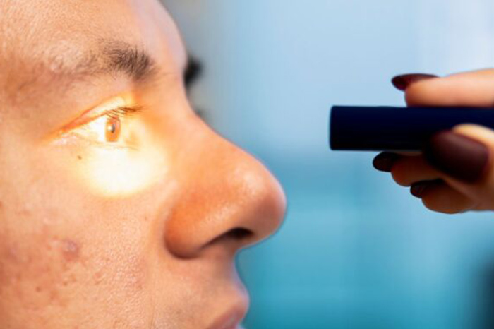 Oftalmólogo revisando los ojos de un paciente.