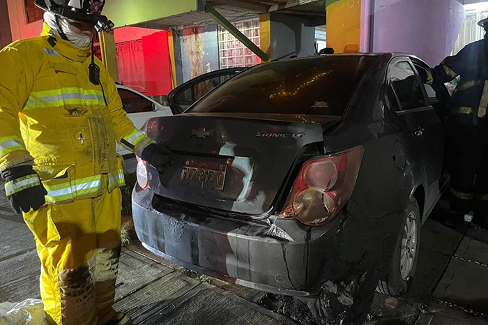 Bomberos municipales trabajan para sofocar las llamas de un vehículo incendiado en el fraccionamiento Valle Real de Uruapan