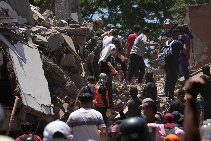 Integrantes del cuerpo de Bomberos de Cali y civiles buscan entre los escombros de edificaciones colapsadas por el terremoto de magnitud 7,4