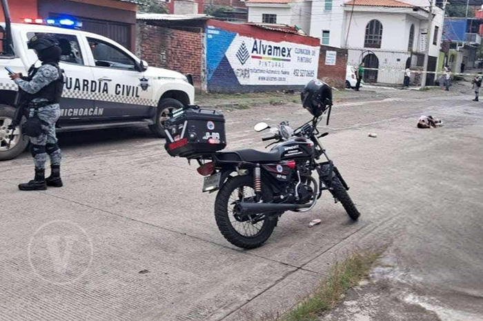 Elementos de seguridad custodiando la zona de una agresión armada en una calle urbana.