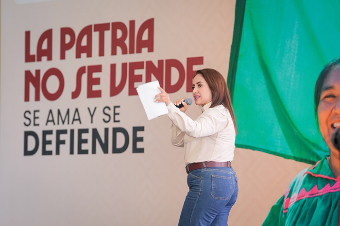 Gladyz Butanda dirigiéndose a simpatizantes durante un evento masivo en un espacio público.