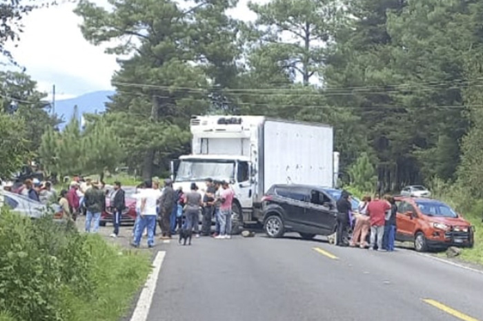 Unidades de carga atravesadas sobre la carpeta asfáltica interrumpiendo el paso vehicular.