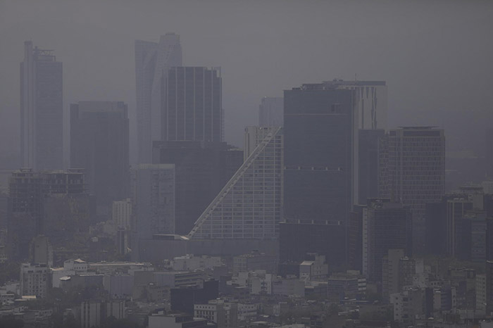 Paisaje urbano con presencia de neblina y partículas de contaminación ambiental.